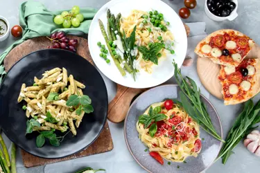 Läskande matbord fotat ovanifrån med pasta, pizza och goda tomatsåser