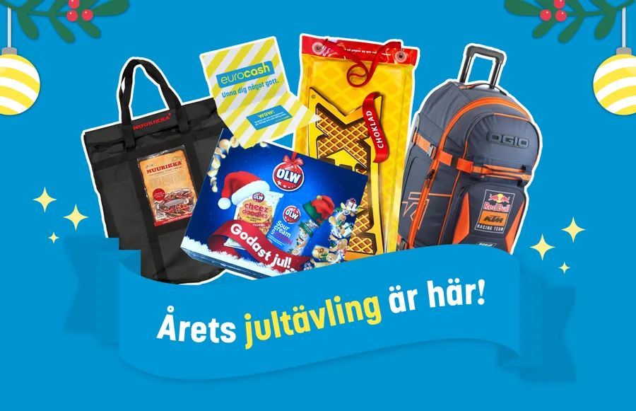 Årets jultävling är här! Står skrivet på en blå banner som ligger ovan produkter som kunder kan vinna under december. Från vänster, Muurekka, presentkort på Eurocash, OLW julkalender, kexchoklad åkmatta och en travel bag från Redbull. 