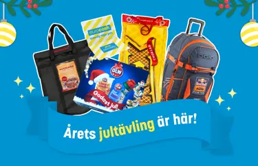 Årets jultävling är här! Står skrivet på en blå banner som ligger ovan produkter som kunder kan vinna under december. Från vänster, Muurekka, presentkort på Eurocash, OLW julkalender, kexchoklad åkmatta och en travel bag från Redbull. 